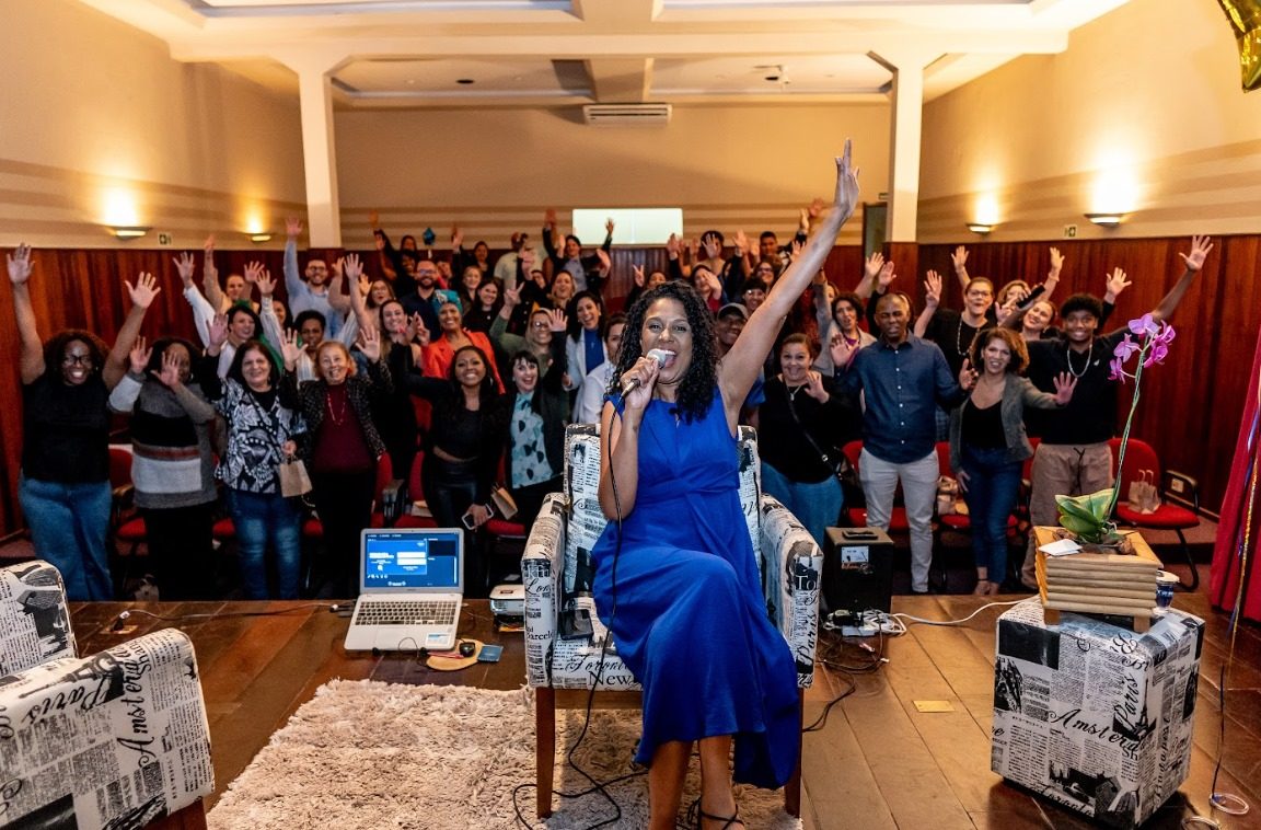 Cintya Santos conduzindo uma palestra corporativa sobre liderança